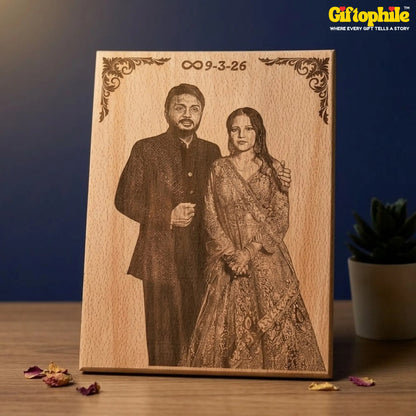 Wooden plaque with laser-engraved portrait of a couple and date, on a wooden surface with a blue background.