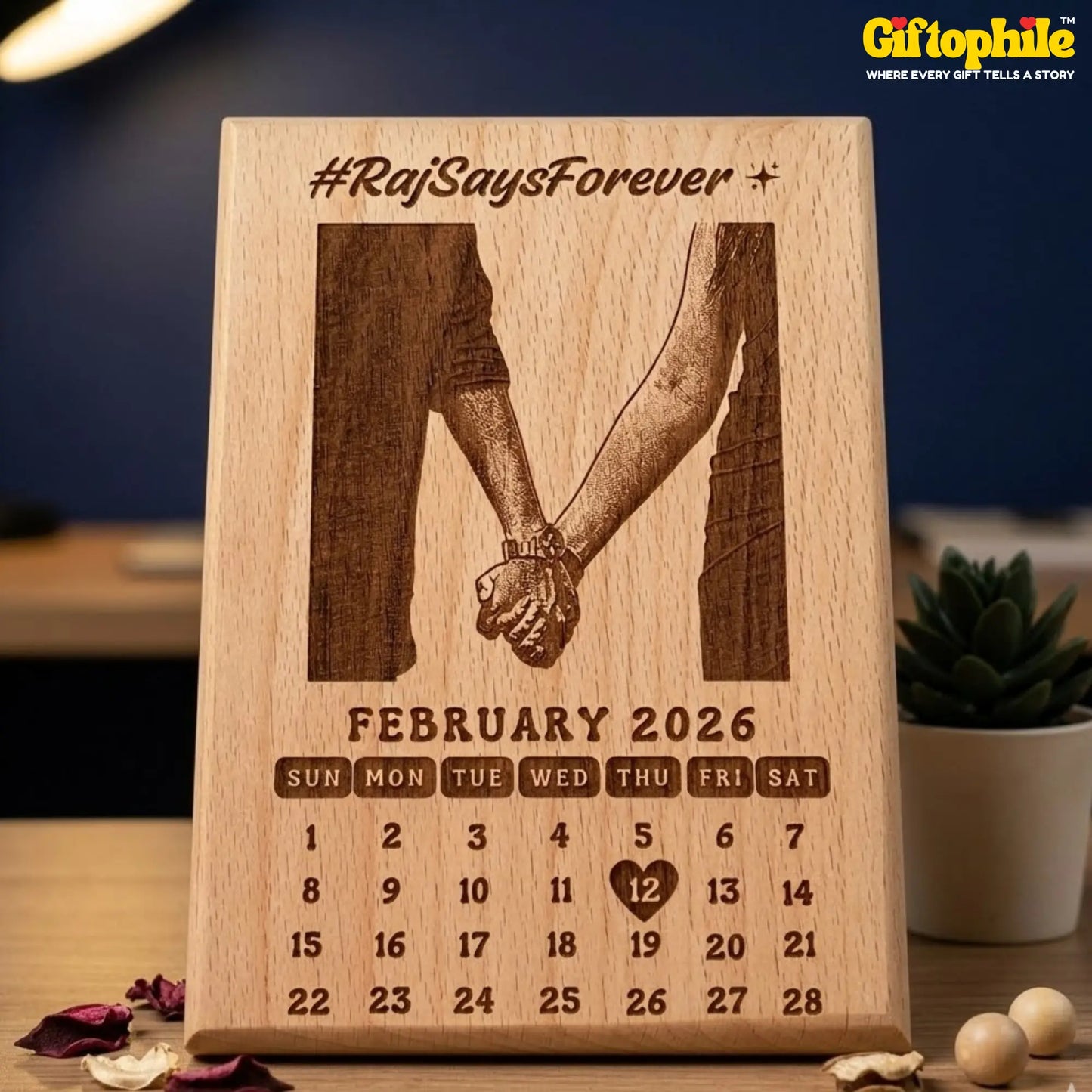 Wooden calendar with engraved design of two hands holding hands and text 'Raj Says Forever' on a blurred background.