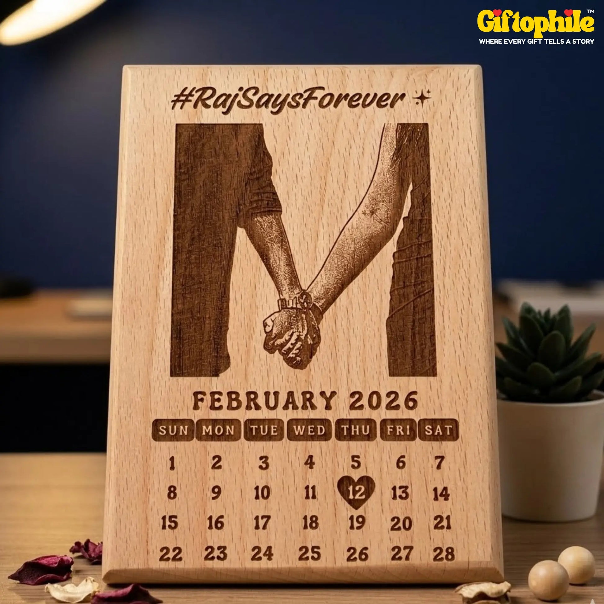 Wooden calendar with engraved design of two hands holding hands and text 'Raj Says Forever' on a blurred background.