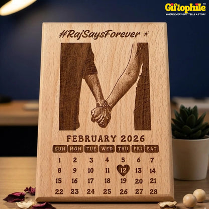 Wooden calendar with engraved design of two hands holding hands and text 'Raj Says Forever' on a blurred background.
